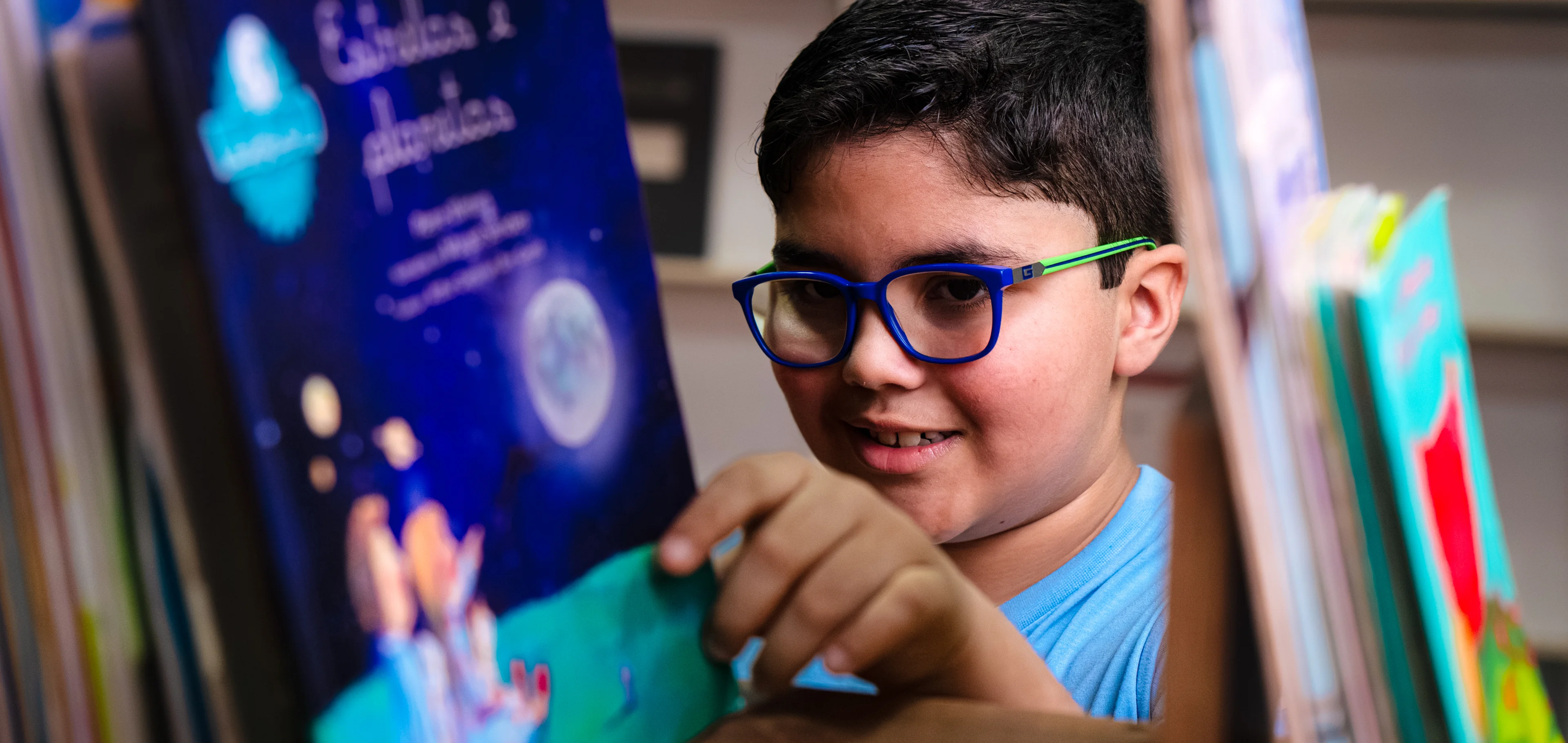 Aluno de óculos pegandoum livro na estante